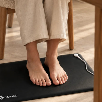 Grounding mat under bare feet at a desk